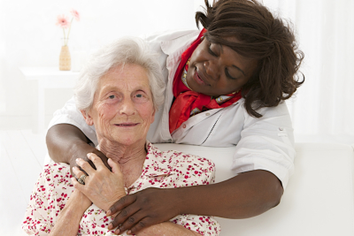 caregiver hugging the senior woman
